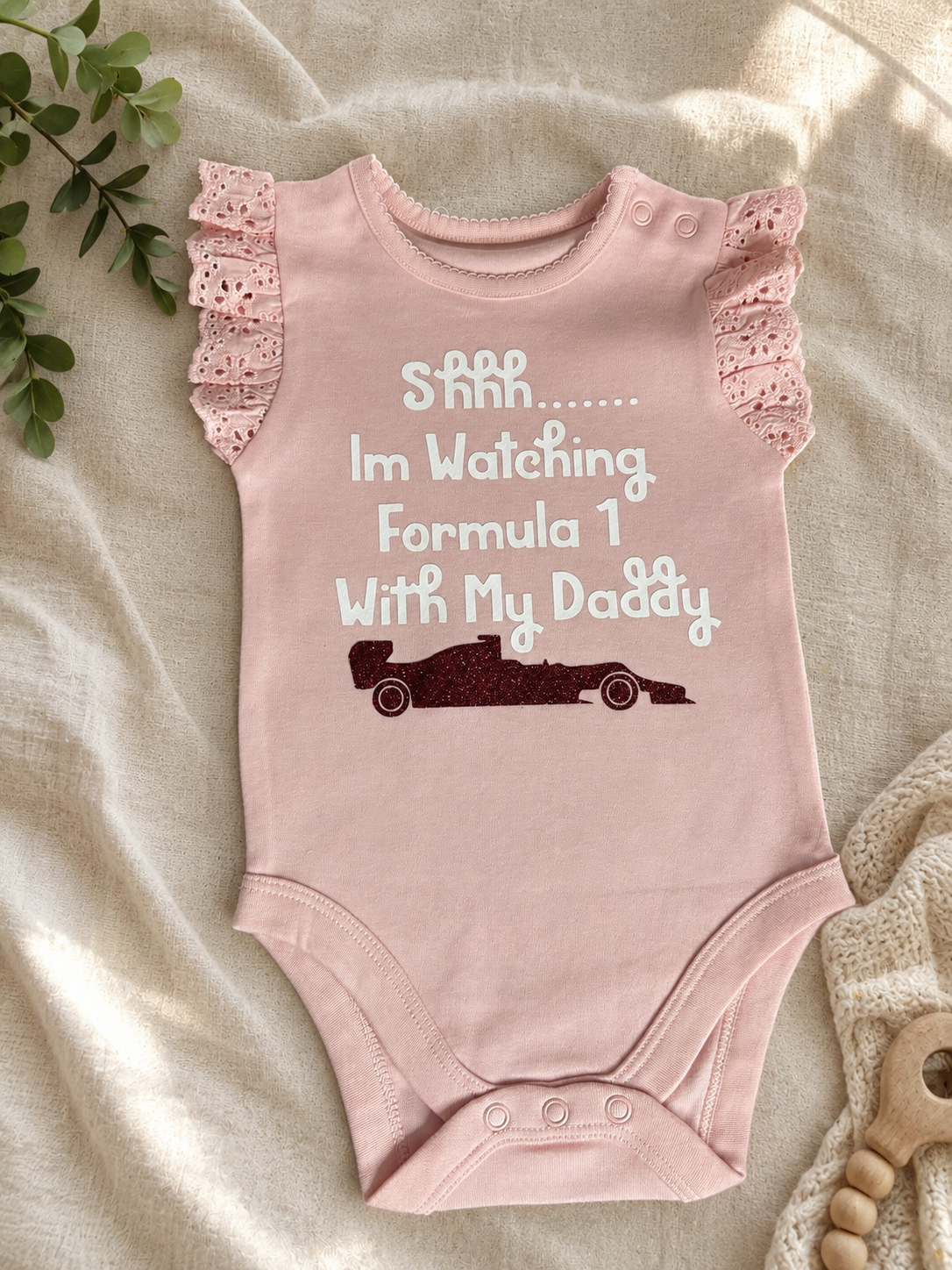 Pink baby bodysuit with Shhh I'm Watching Formula 1 With My Daddy print and lace frill sleeves