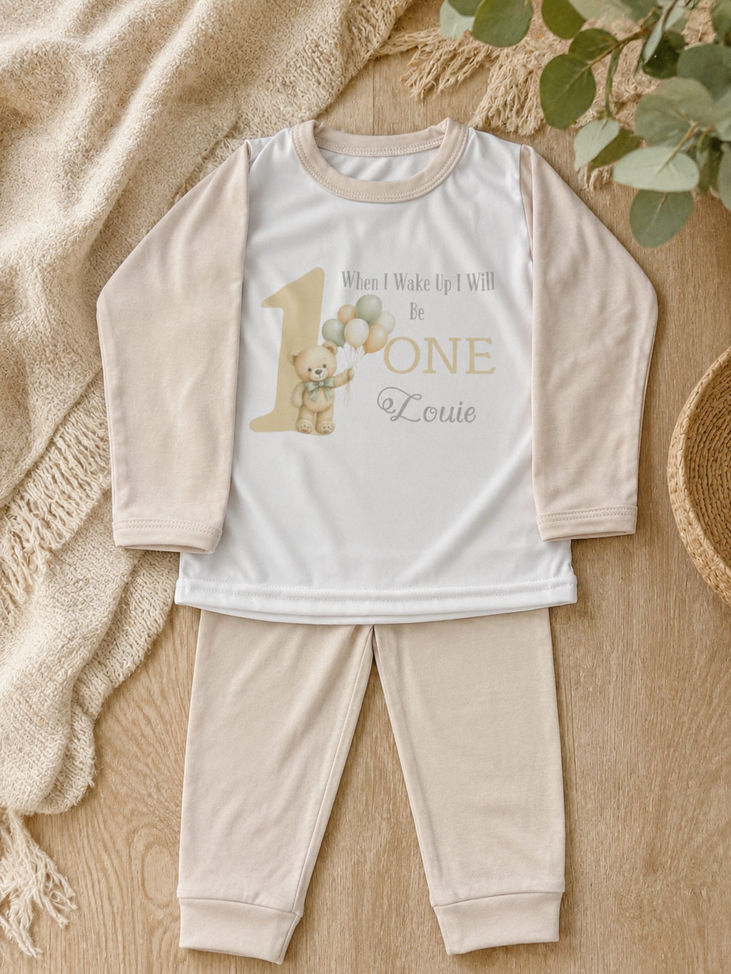 Baby wearing personalised birthday pyjamas at first birthday party with teddy bear theme