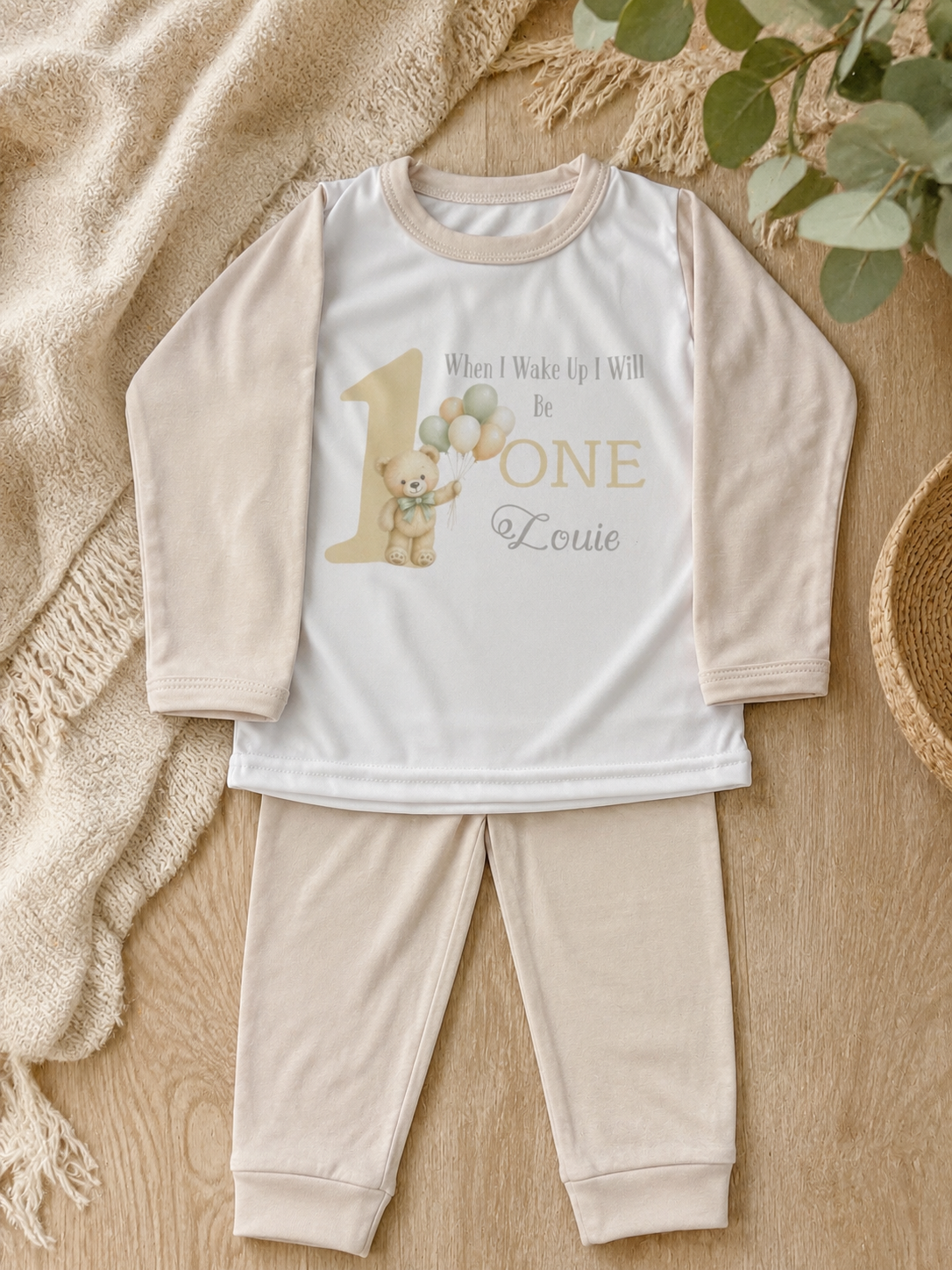 Baby wearing personalised birthday pyjamas at first birthday party with teddy bear theme